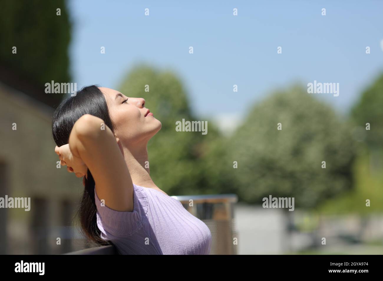 Side view portrait of an asian woman resting sitting on a bench in a ...