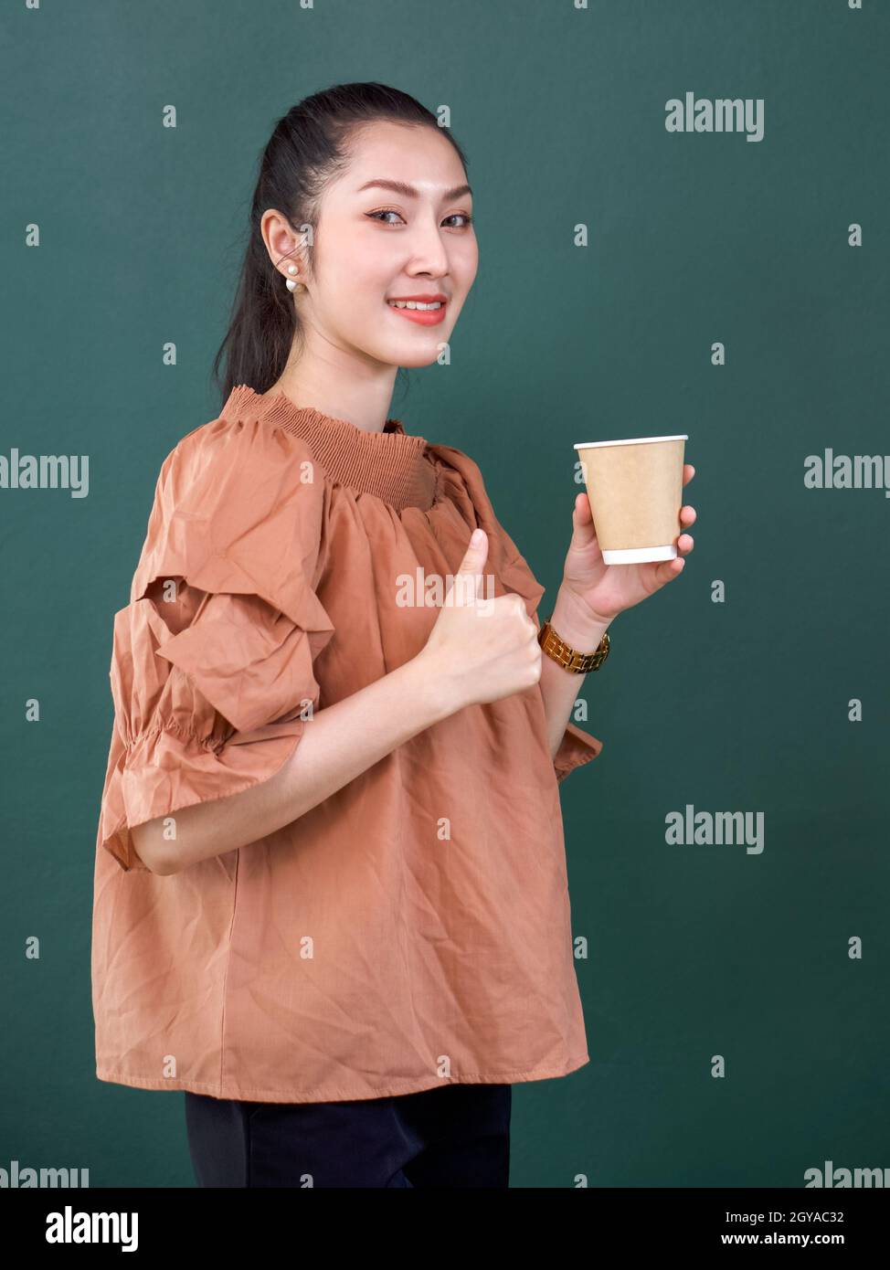 Young asian woman in casual dress with a smile holding coffee drink in ...