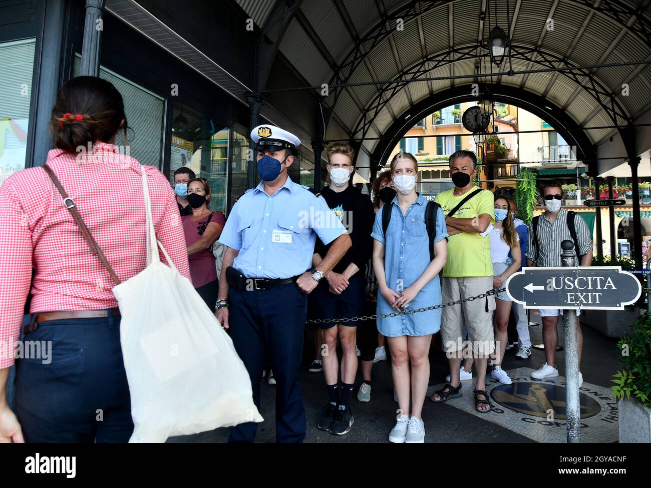 Passengers wearing Covid 19 pandemic face masks as they wait to board boat on Lake Como, Italy Stock Photo