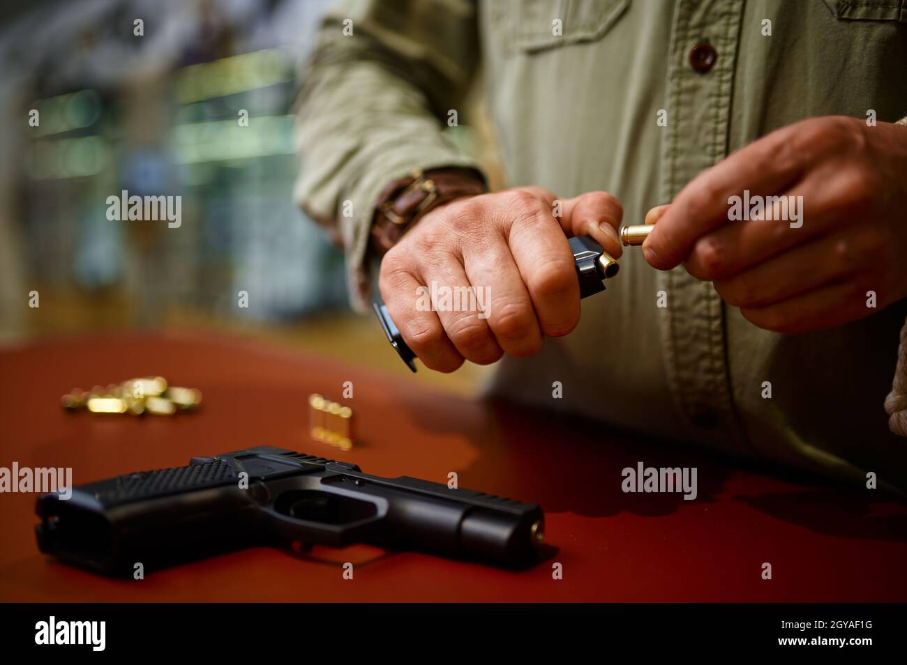 Man loads the magazine with bullets in gun store. Weapon shop interior