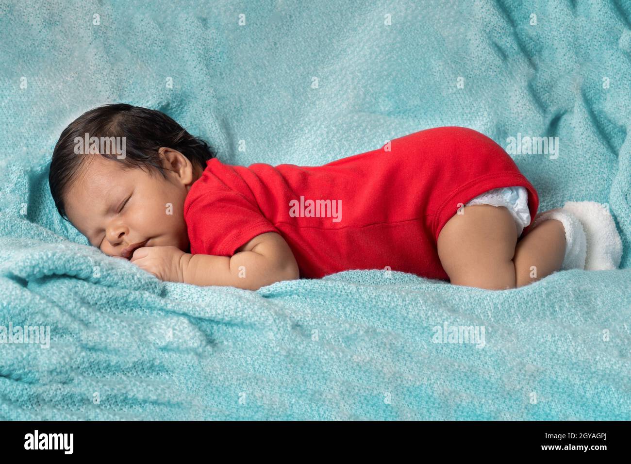 Baby sleeping on his stomach, dressed in red clothes Stock Photo Alamy