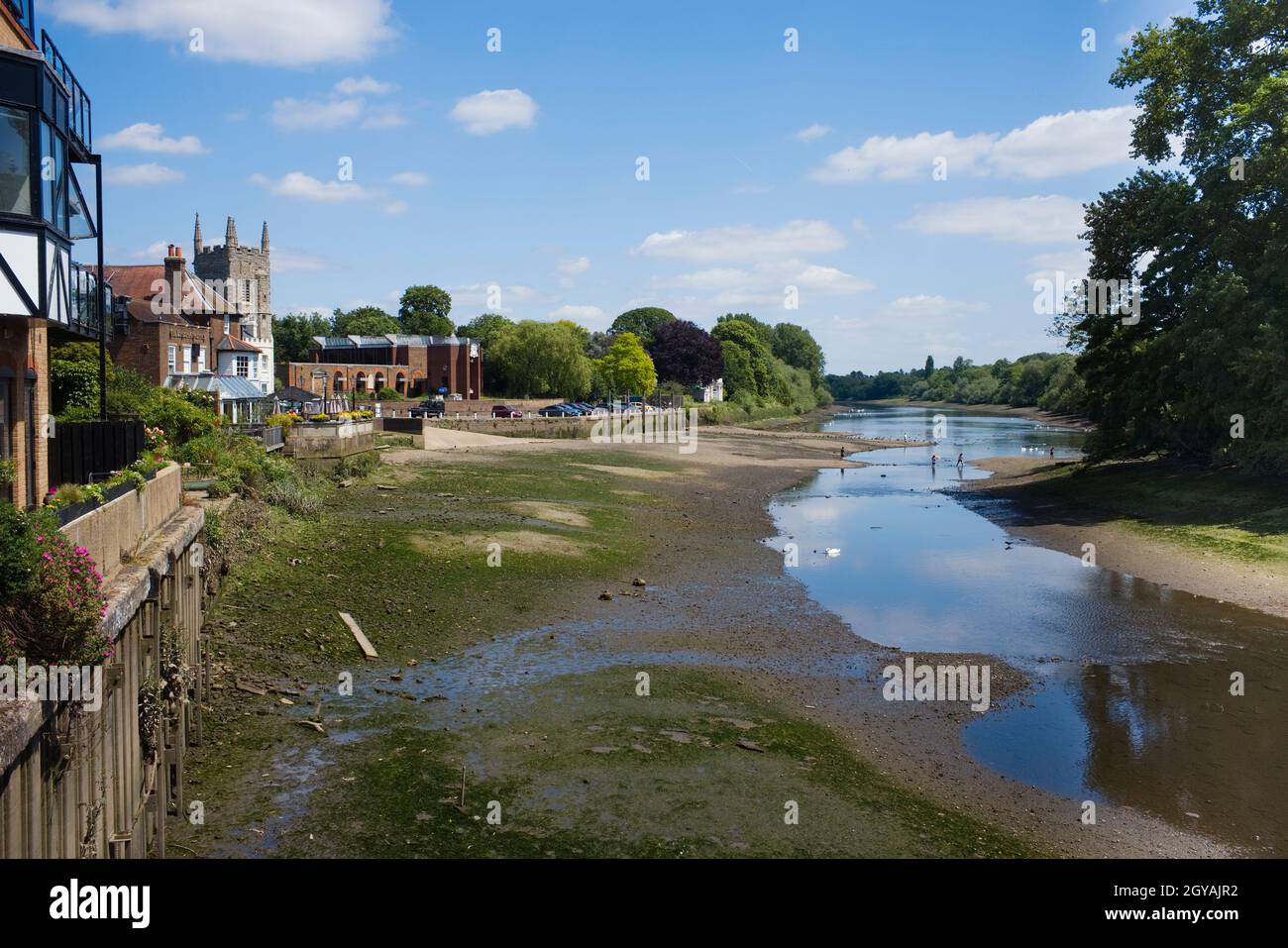 The river Thames at an extreme low tide looking downstream with people wading over to Isleworth Ait Stock Photo