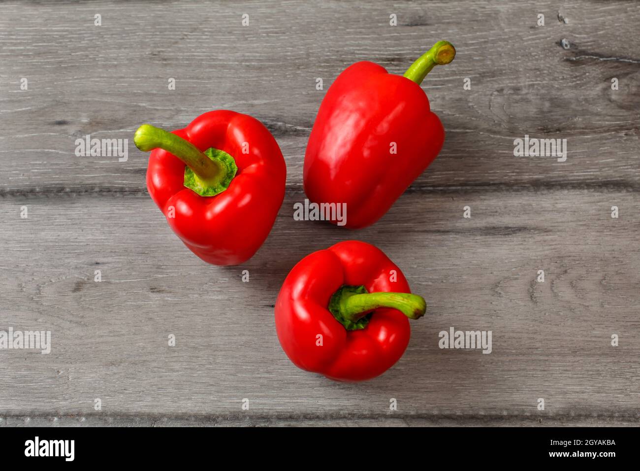 Table top view - three red bell peppers on gray wood desk Stock Photo ...
