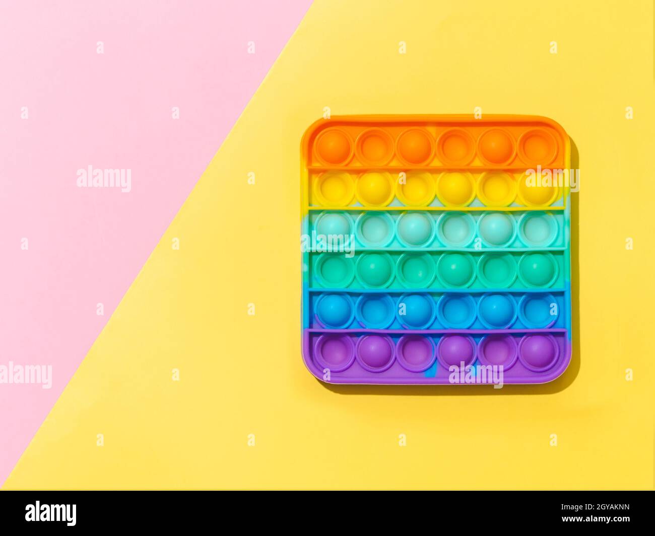 Popit on yellow and pink background with copy space. Popular silicone ...