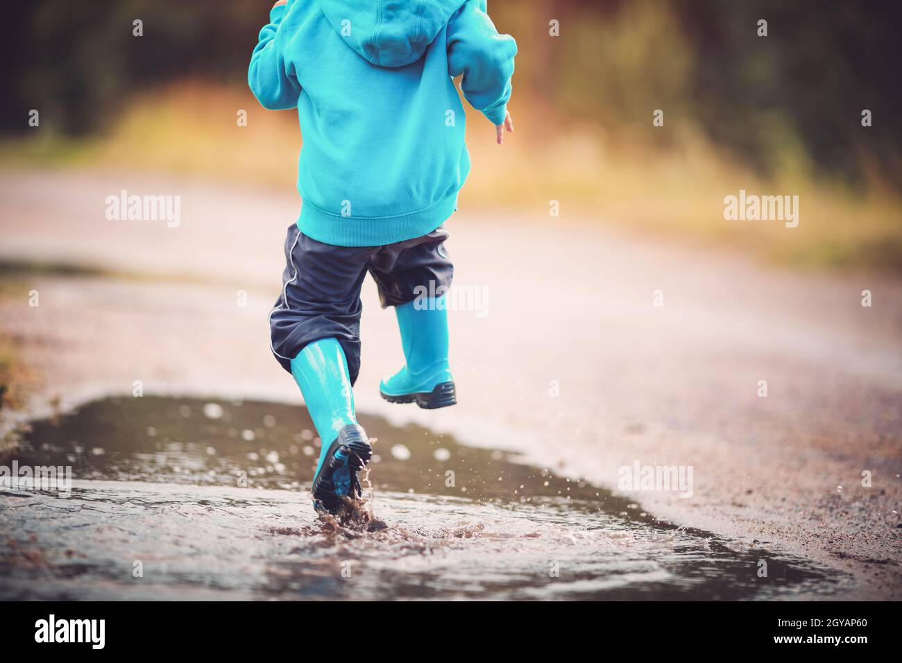 Boy jumping in puddle hi-res stock photography and images - Alamy