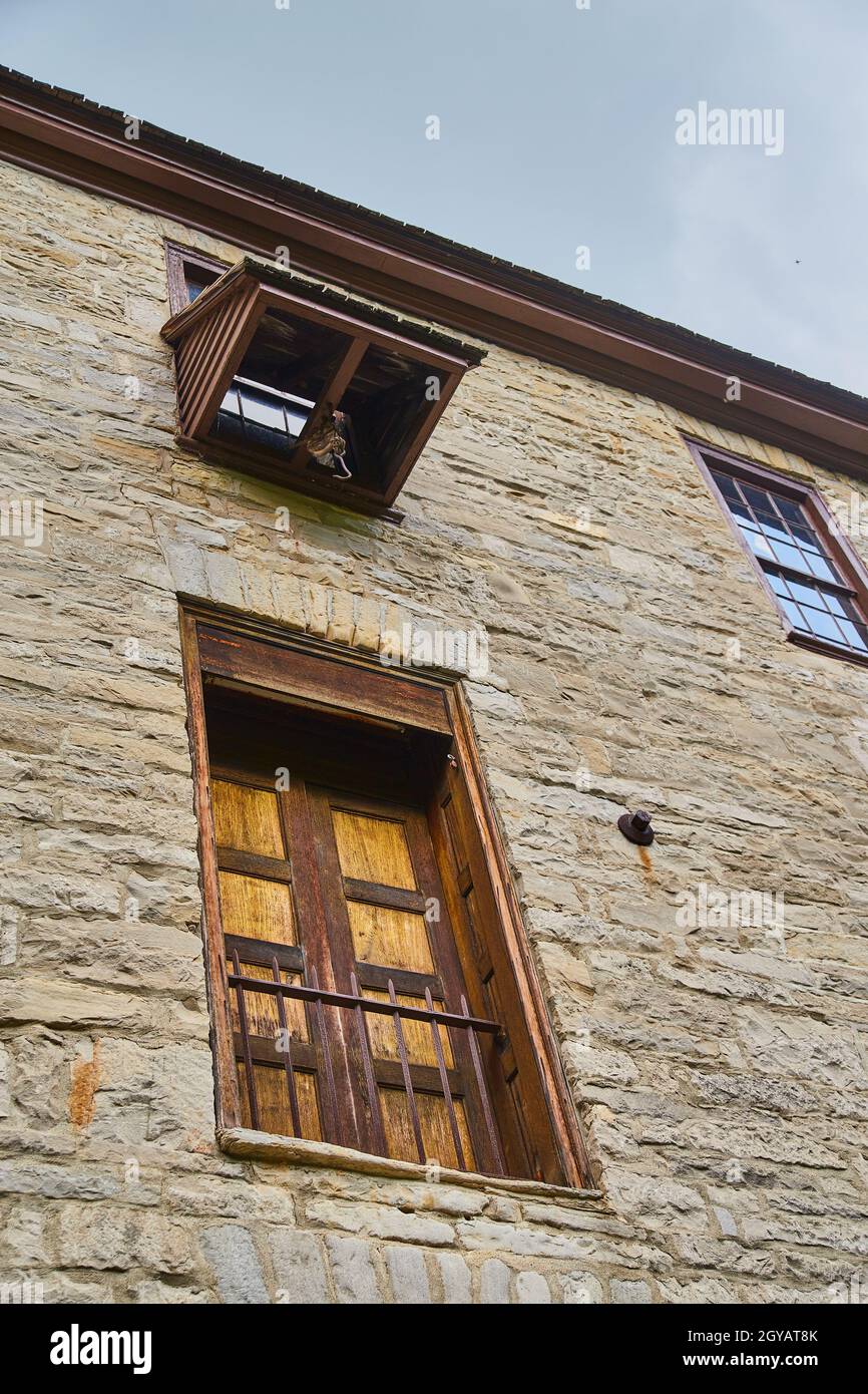 Old stone building with double wooden fenced in doors and a crane lift for delivery Stock Photo