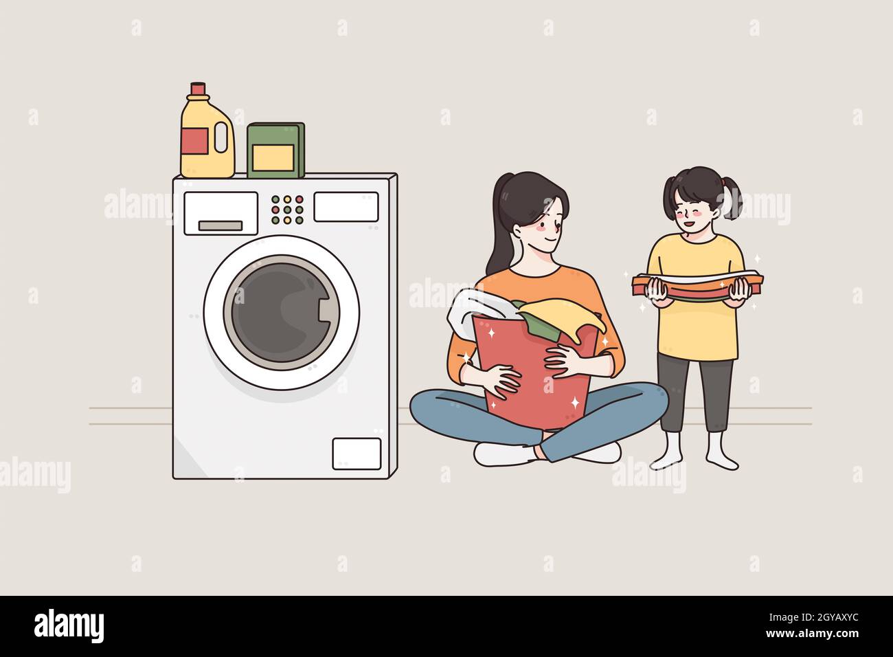 Laundry and spending time with children concept.Young smiling happy woman and her small daughter cartoon characters sitting on floor preparing dirty c Stock Photo