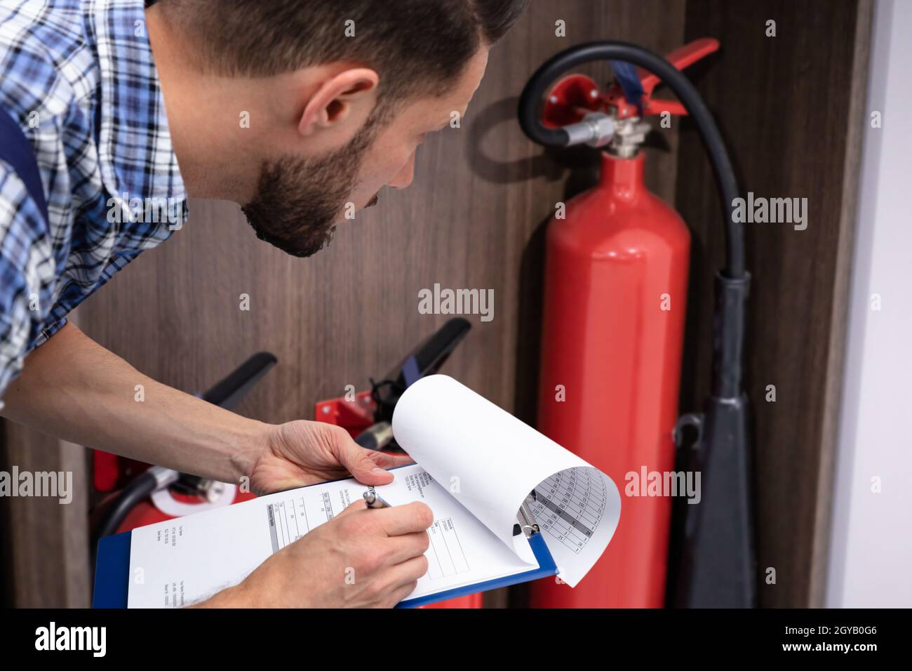 Checking Fire Extinguisher. Safety And Emergency Prevention Stock Photo
