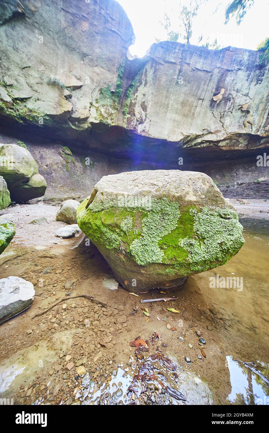 Large boulder with moss on in inside a dried-up waterfall basin Stock Photo