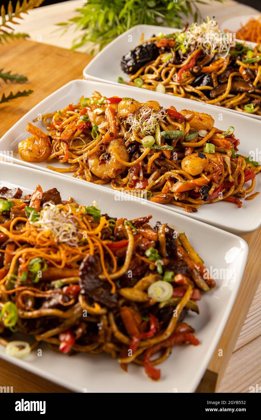 Spicy Chinese stir fry noodles. Three portions of Asian food Stock