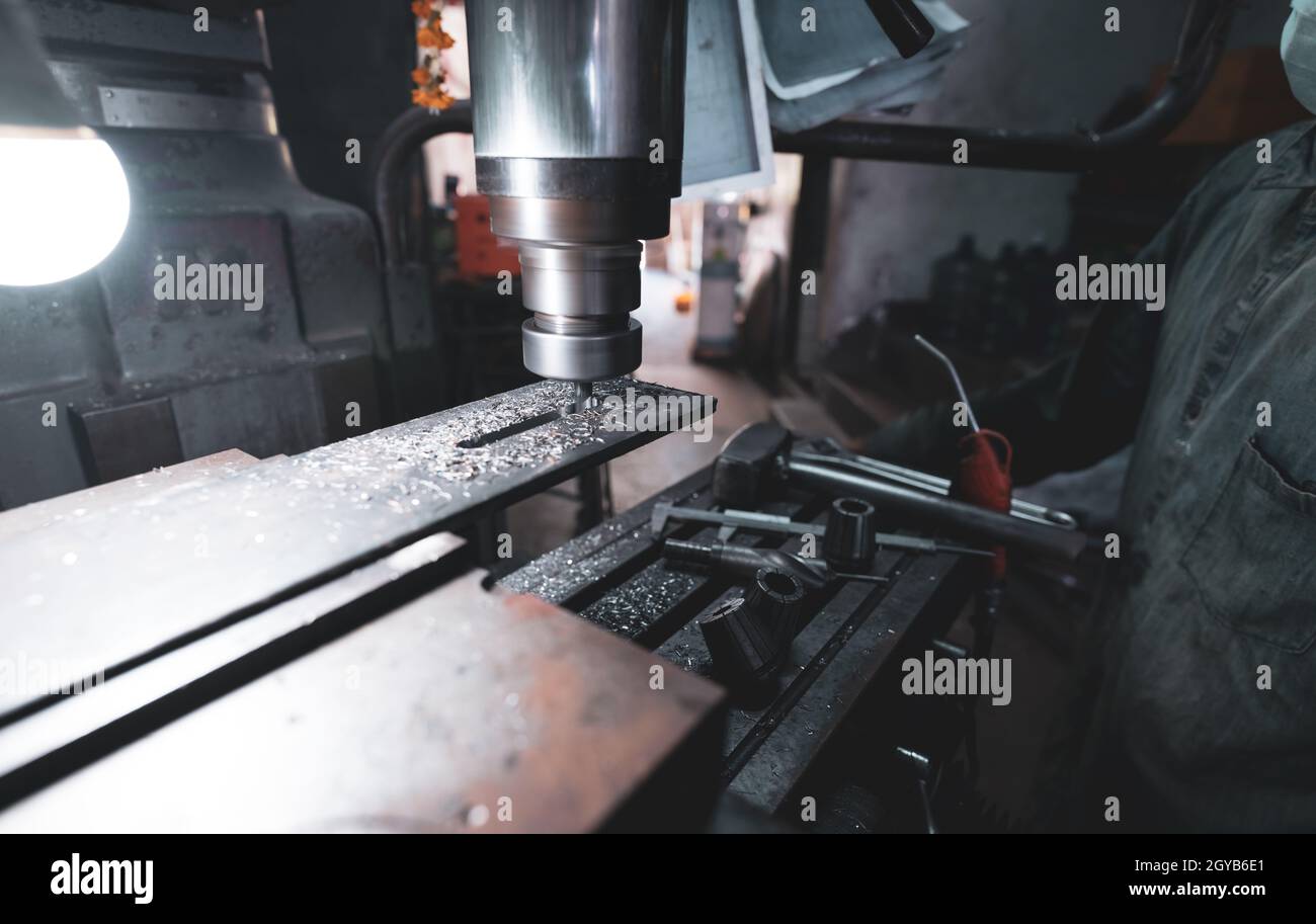 Milling machine working near worker with a protective mask. Tool for
