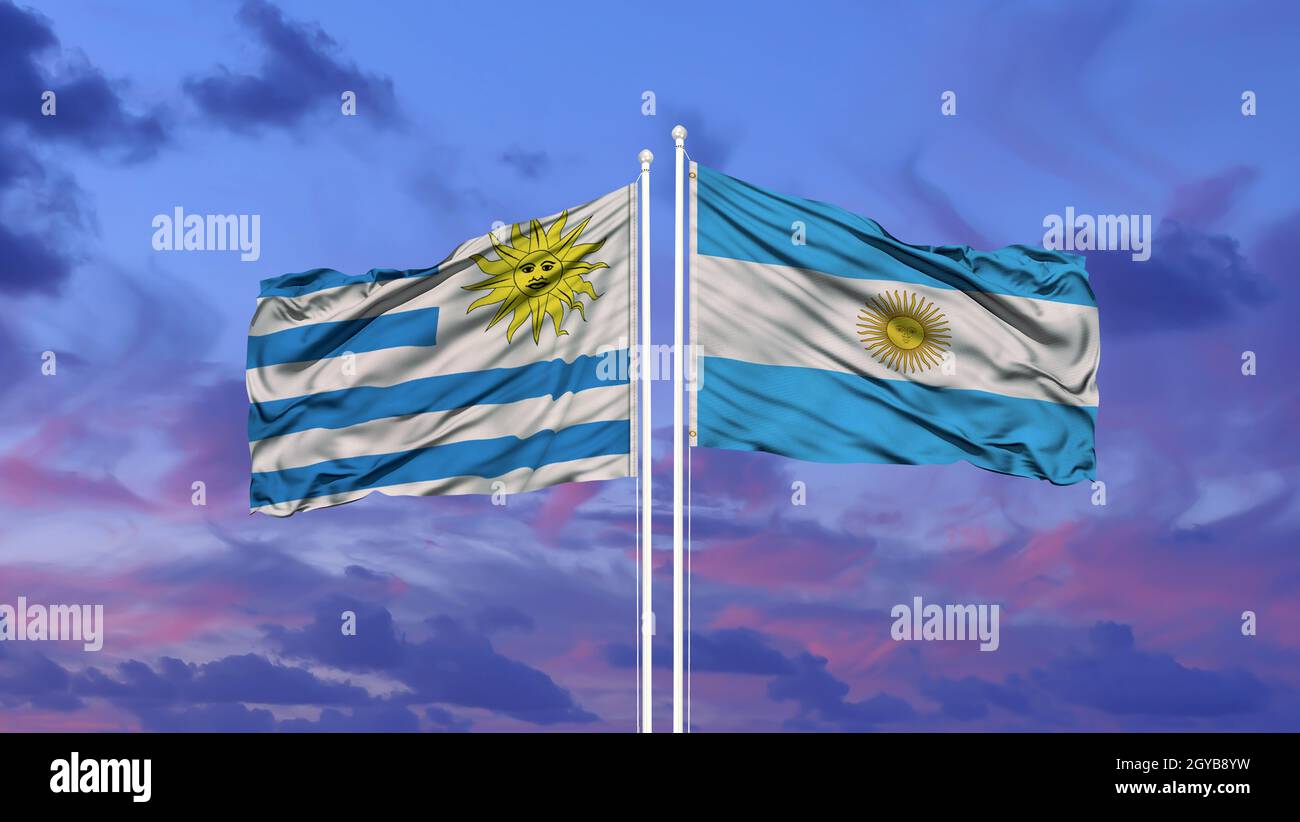Argentina And Uruguay Two Flags On Flagpoles And Blue Sky 2GYB8YW 