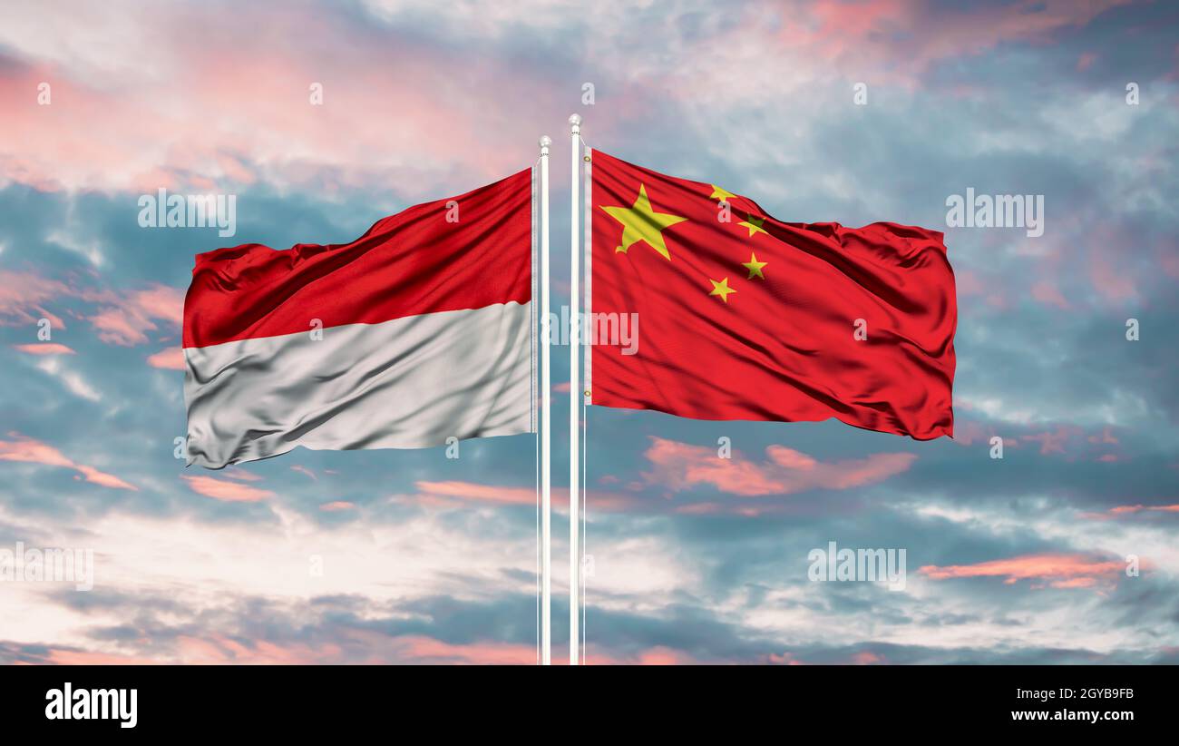 China and Indonesia flag waving in the wind against white cloudy blue sky together. Diplomacy concept, international relations. Stock Photo