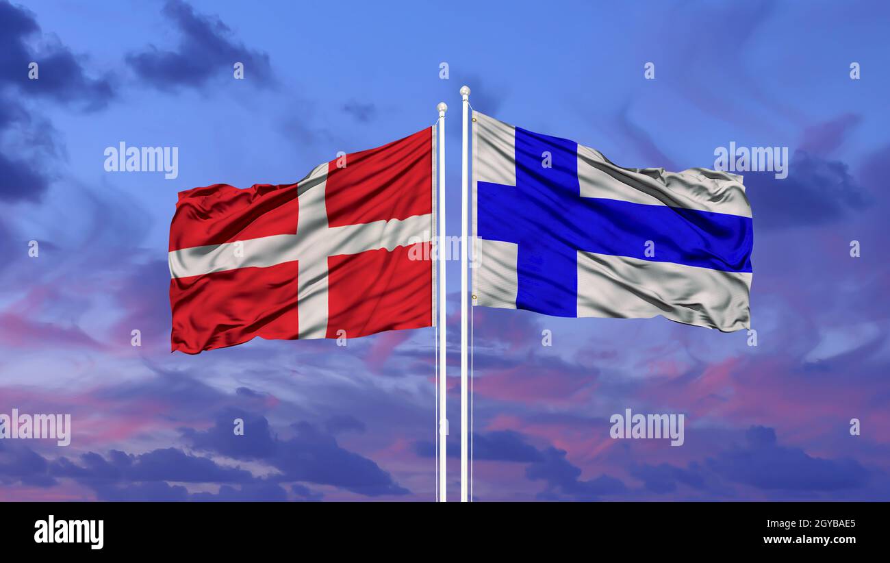 Denmark and Finland flag waving in the wind against white cloudy blue sky together. Diplomacy concept, international relations. Stock Photo