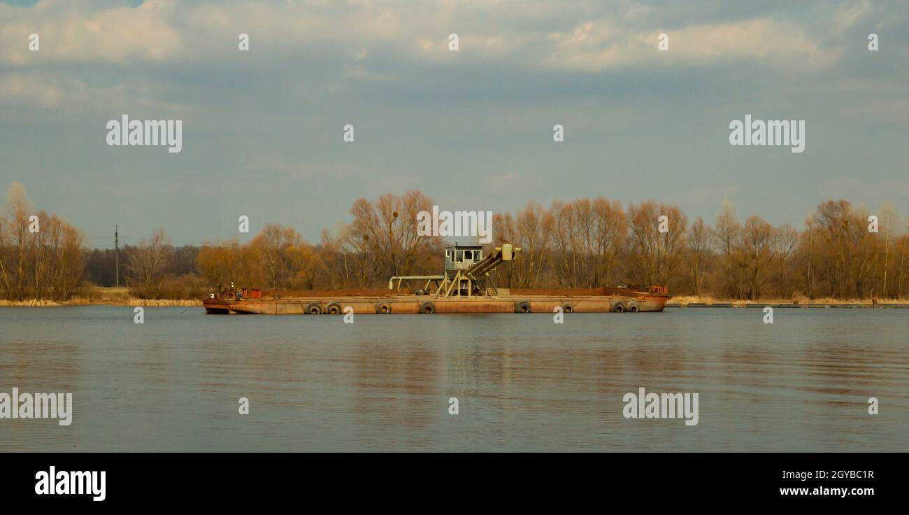 barge on the river in the spring on a sunny day against the blue sky Stock Photo