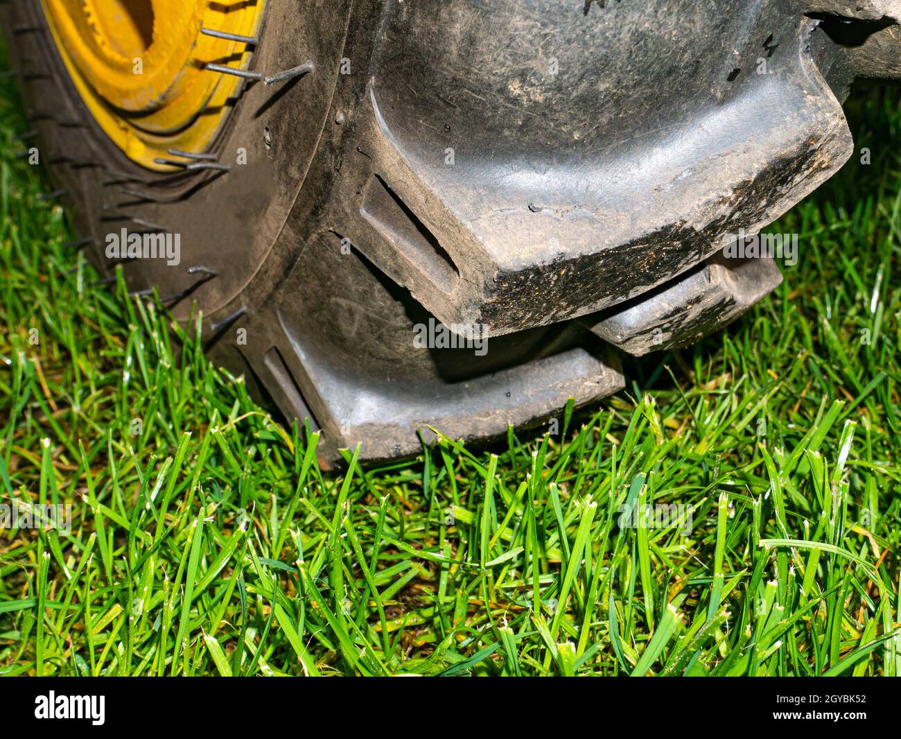 Agricultural tractor wheel on a green grass lawn. Car tire fitting