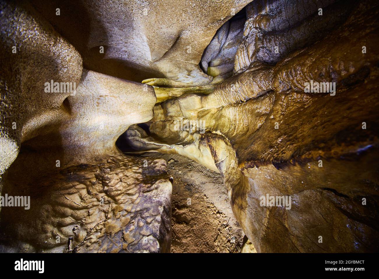 Smooth cave walls with an eerie yellow and white light Stock Photo