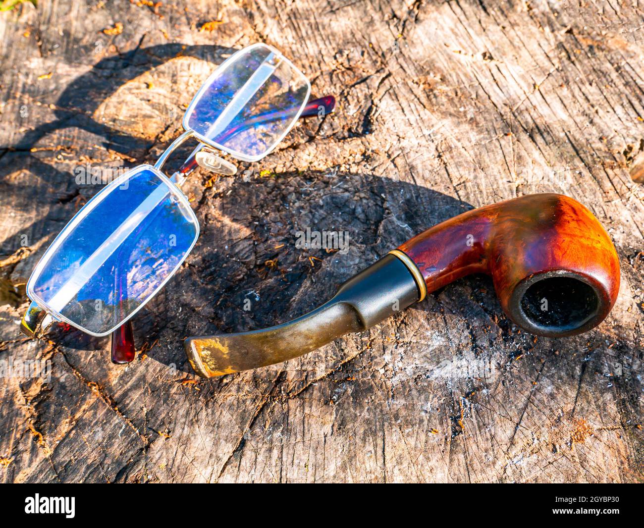 Smoking pipe for tobacco and glasses on a wooden table. Wooden pipe for ...