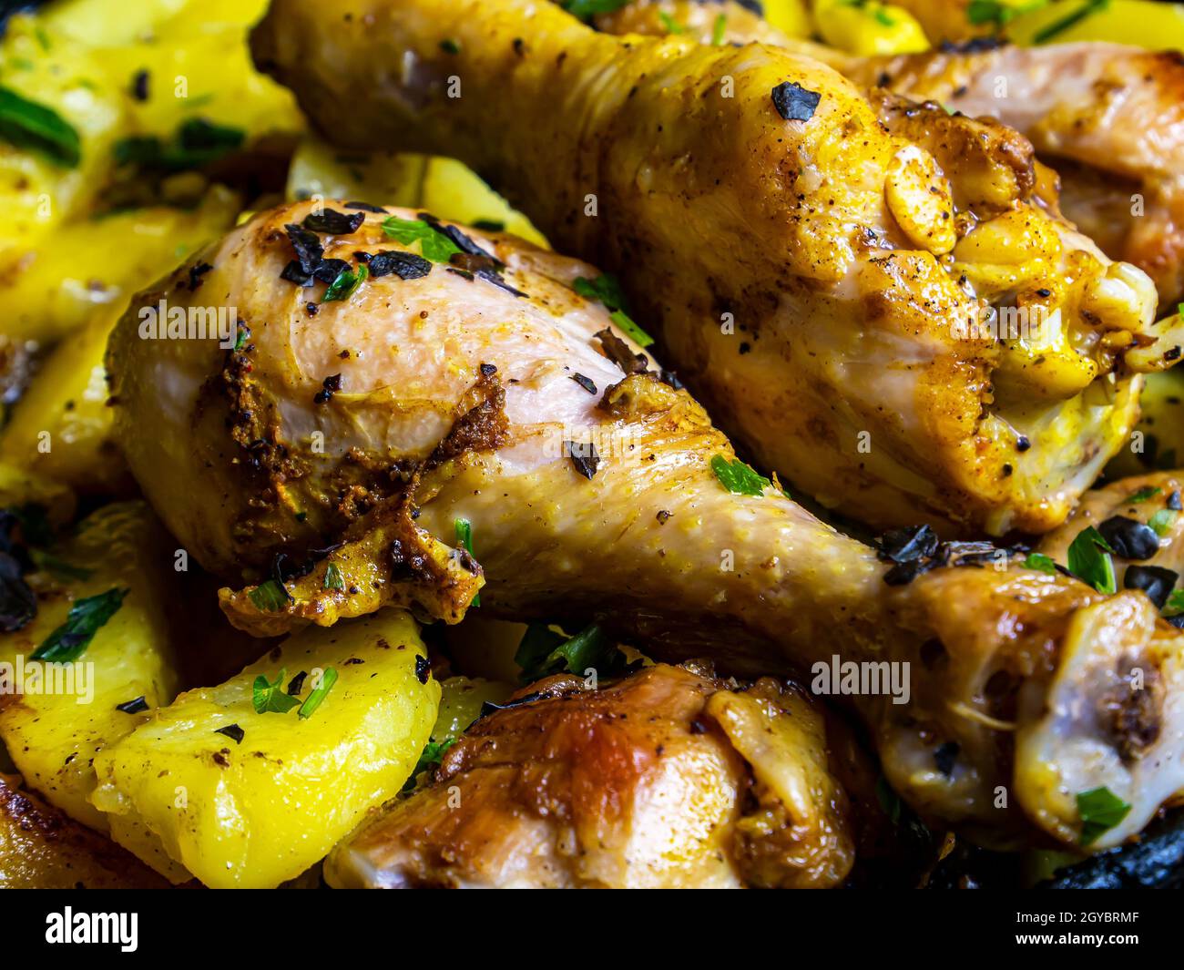 Fried potatoes with chicken leg seasoned with herbs. Roast potatoes