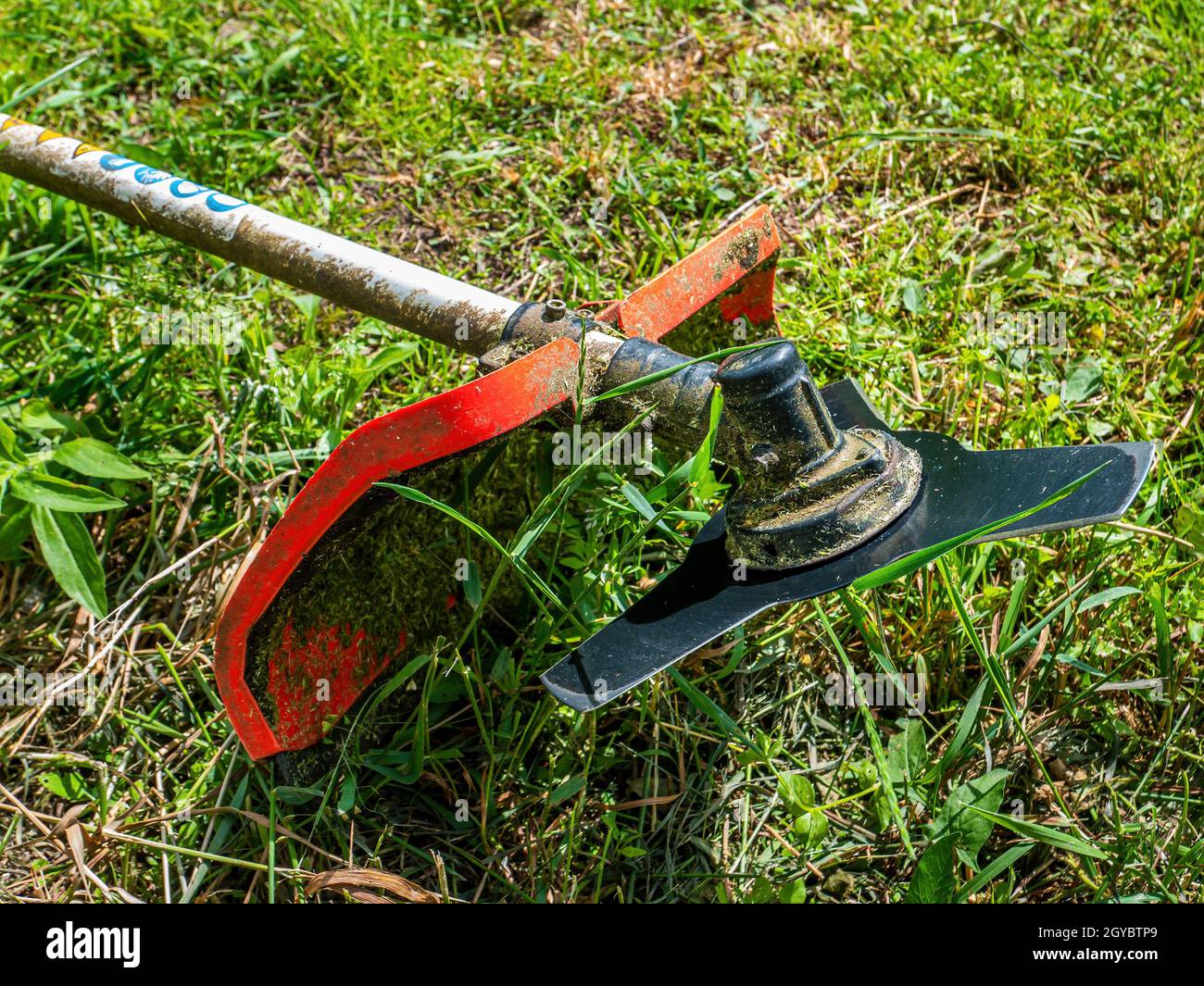 Lawn mower cutting disc for lawn mowing. Blade of knife. Trimmer cutting disc. Mow the grass with a lawn mower. Safety precautions. Garden equipment. Stock Photo