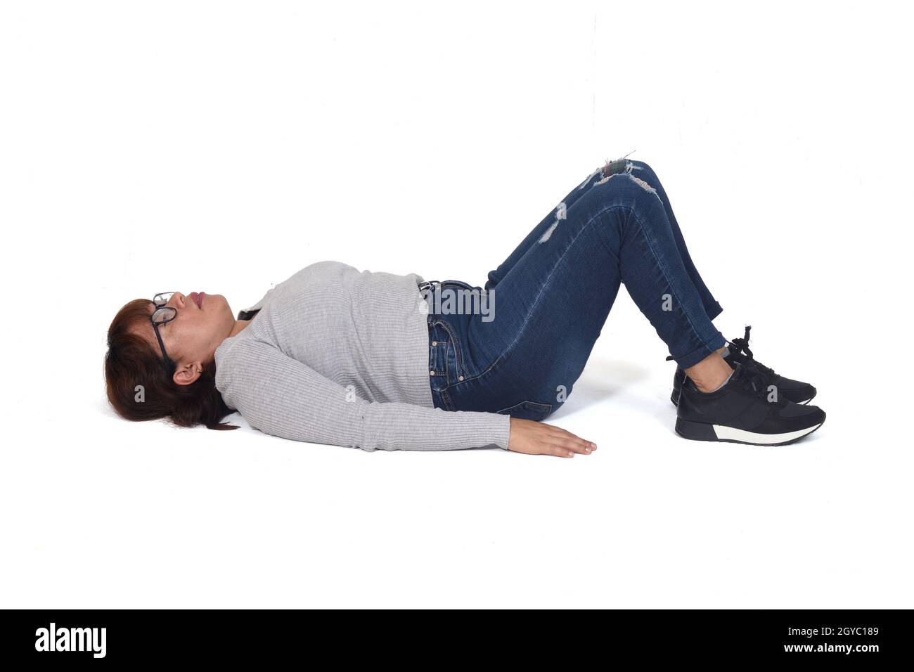 woman lying on the floor with her legs drawn up on white background Stock  Photo - Alamy