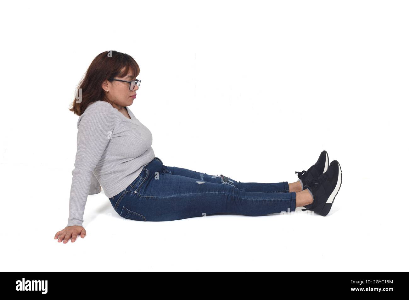 woman sitting on the floor on white background Stock Photo - Alamy