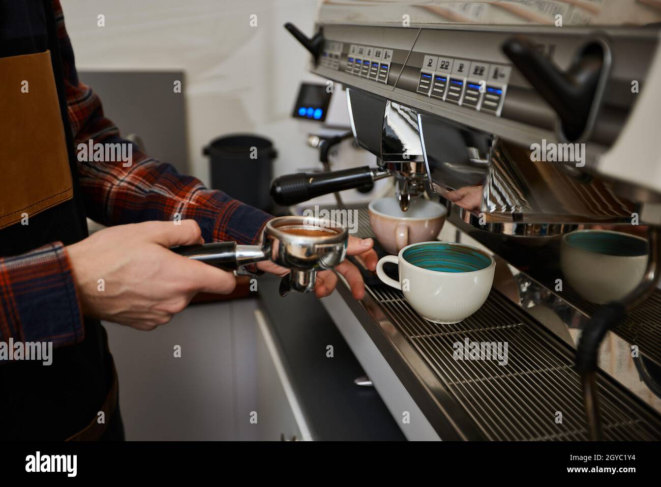 hands of barista preparing coffee espresso using coffee machine in cafe