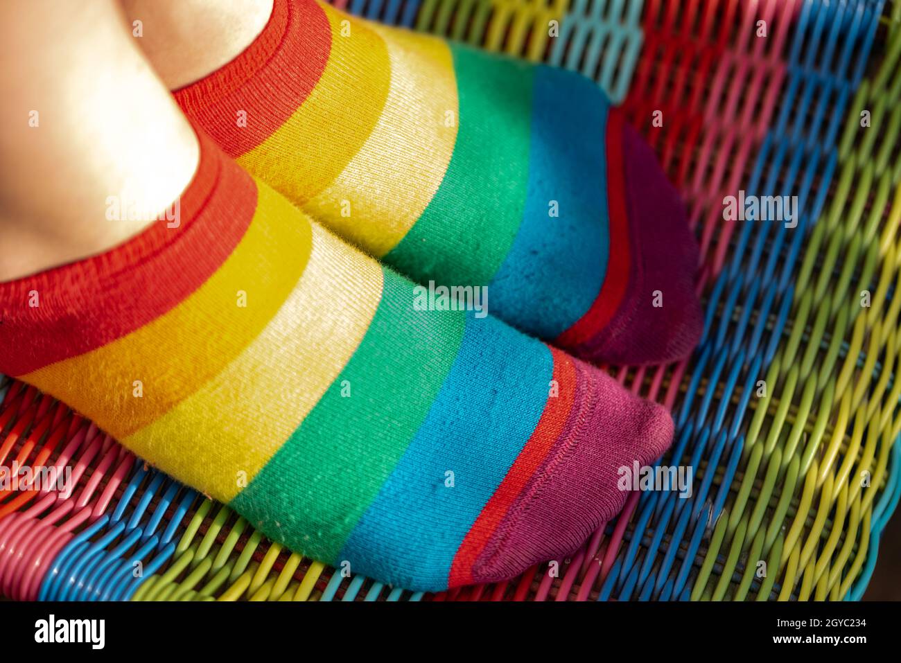 Rainbow socks on the girl's feet. Child's feet in colorful socks on the
