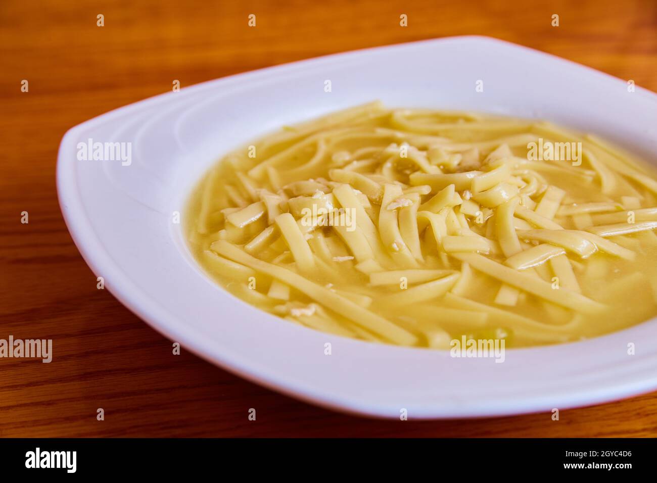 Clean white bowl with warm and hearty chicken noddle soup Stock Photo