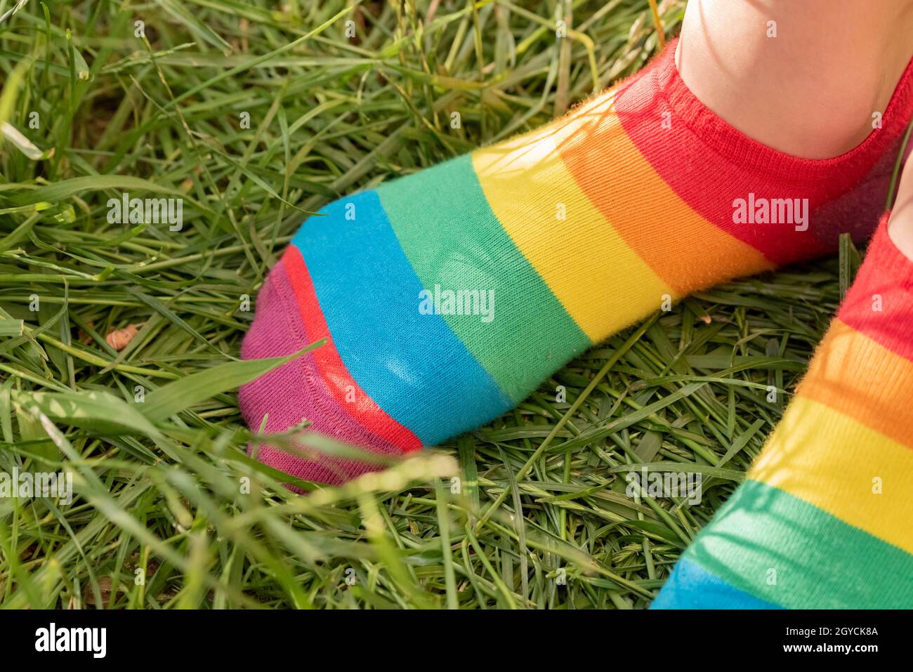 https://c8.alamy.com/comp/2GYCK8A/rainbow-socks-on-the-girls-feet-childs-feet-in-colorful-socks-on-the-green-grass-2GYCK8A.jpg