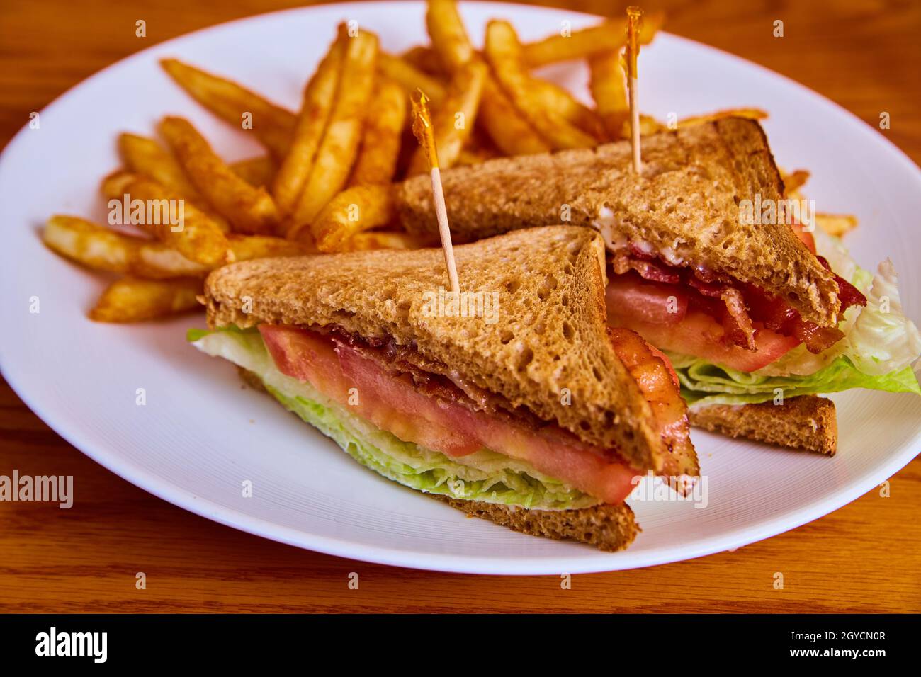 Classic and traditional BLT sandwich with french fries on white plate Stock Photo
