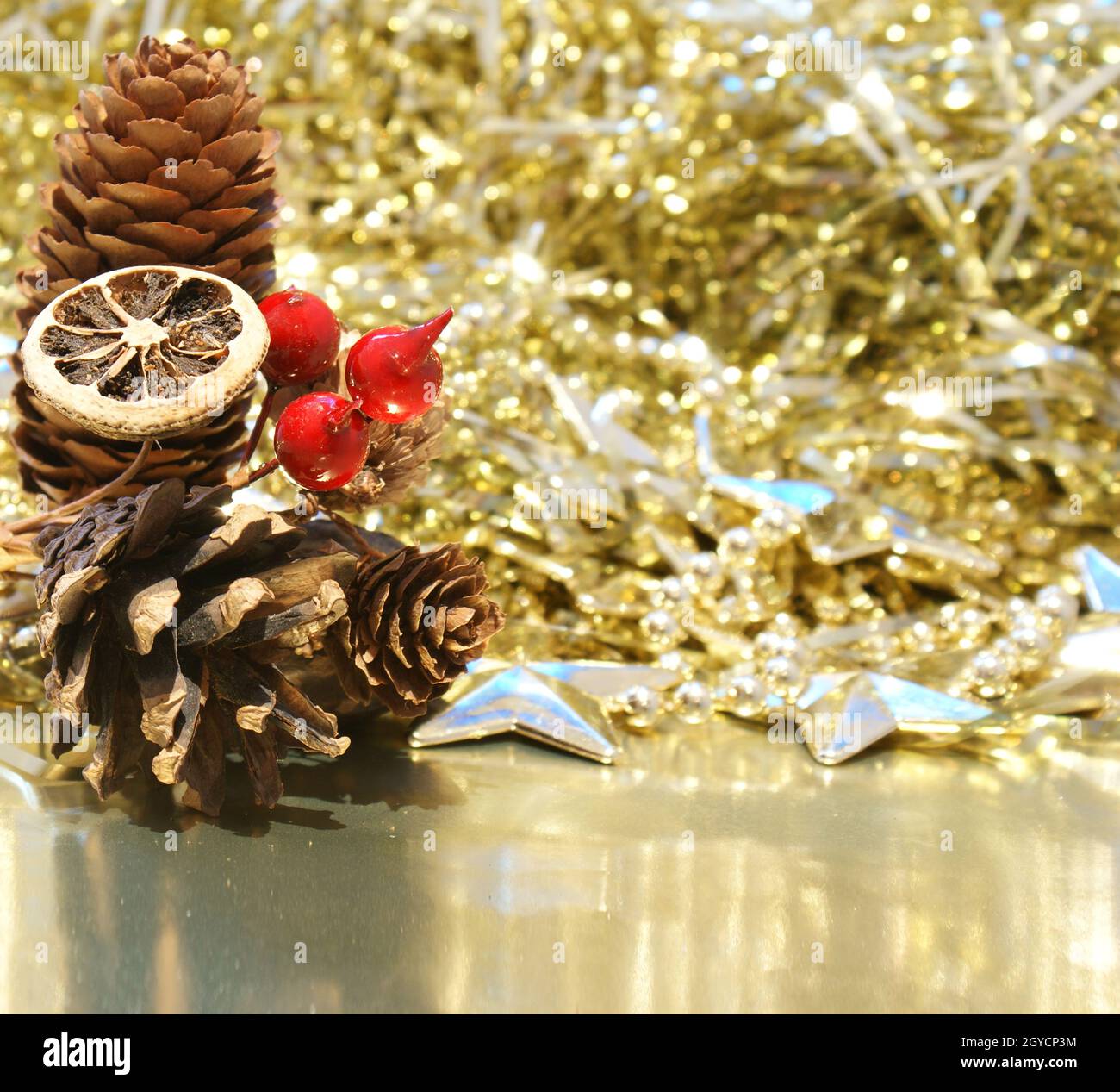 Christmas background with pine cones and berries on a gold background ...