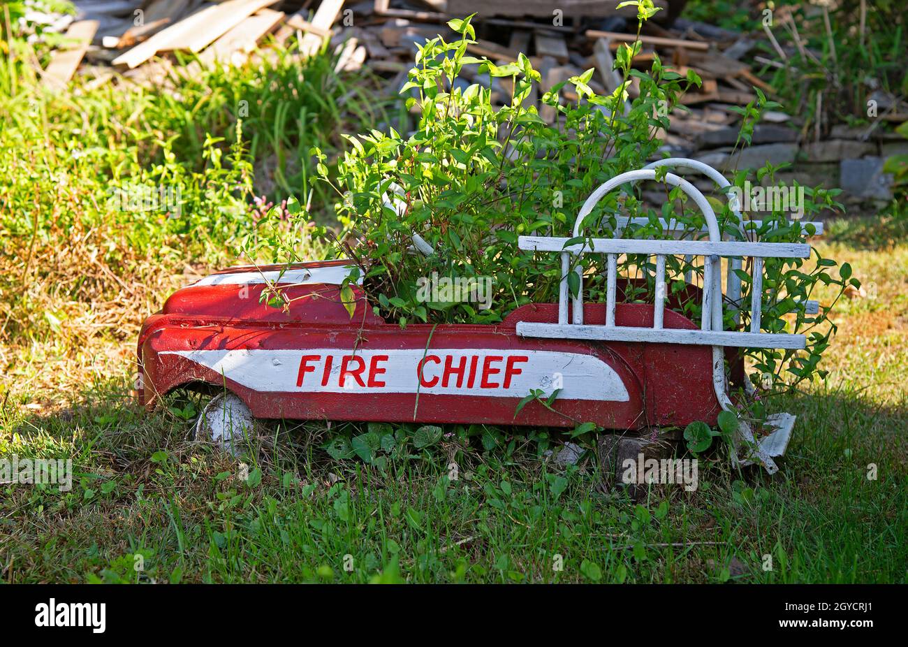 An antique child's toy peddle car, now a planter in Chester, Massachusetts, USA Stock Photo