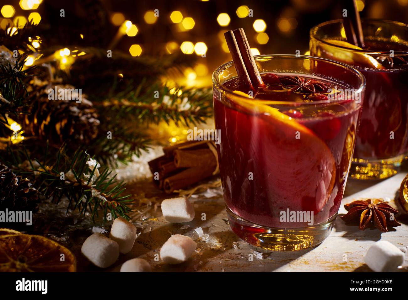 Mulled wine with spices and fruits on wooden table Stock Photo