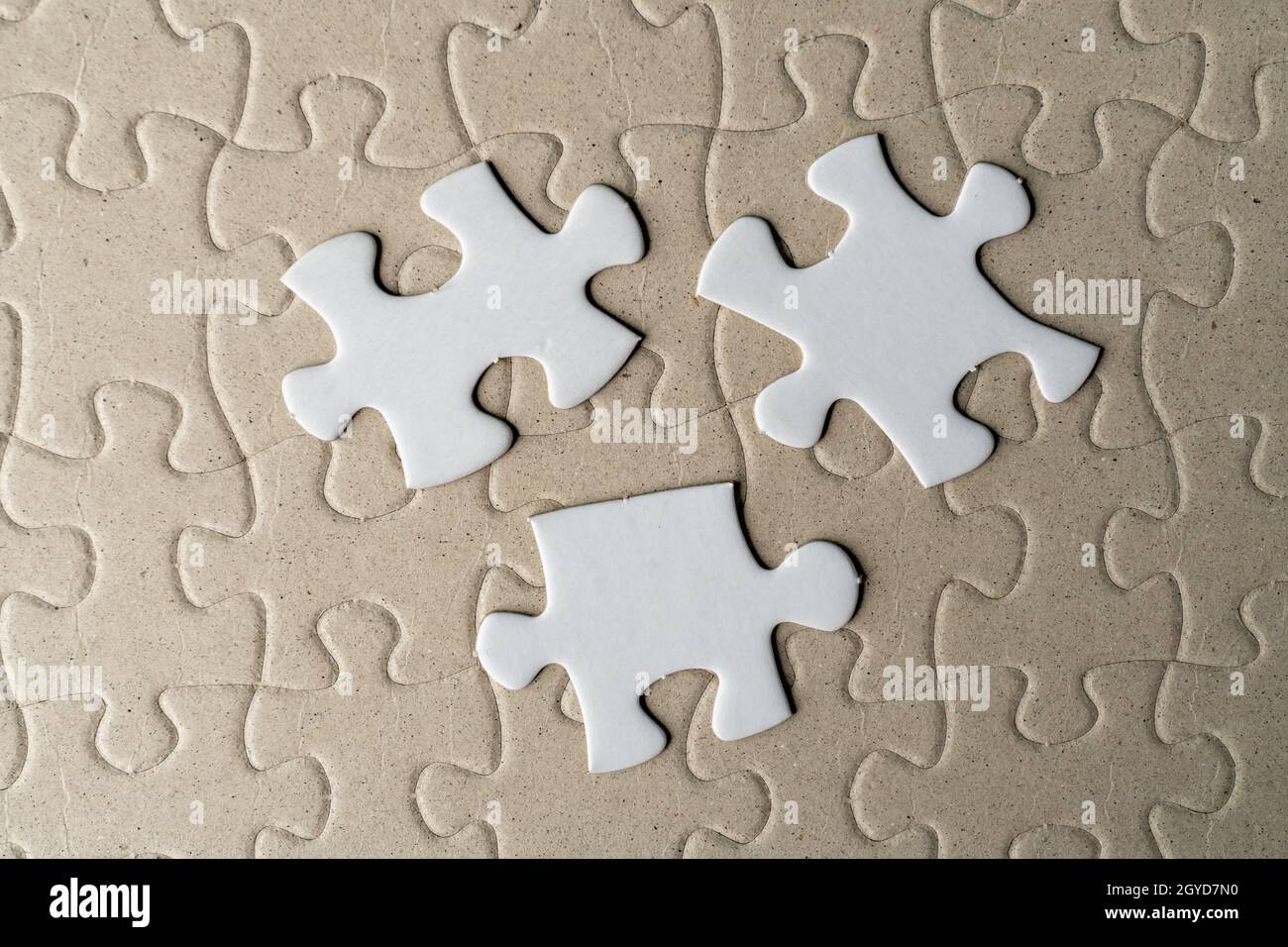 Three pieces of jigsaw puzzle on incomplete puzzle Stock Photo