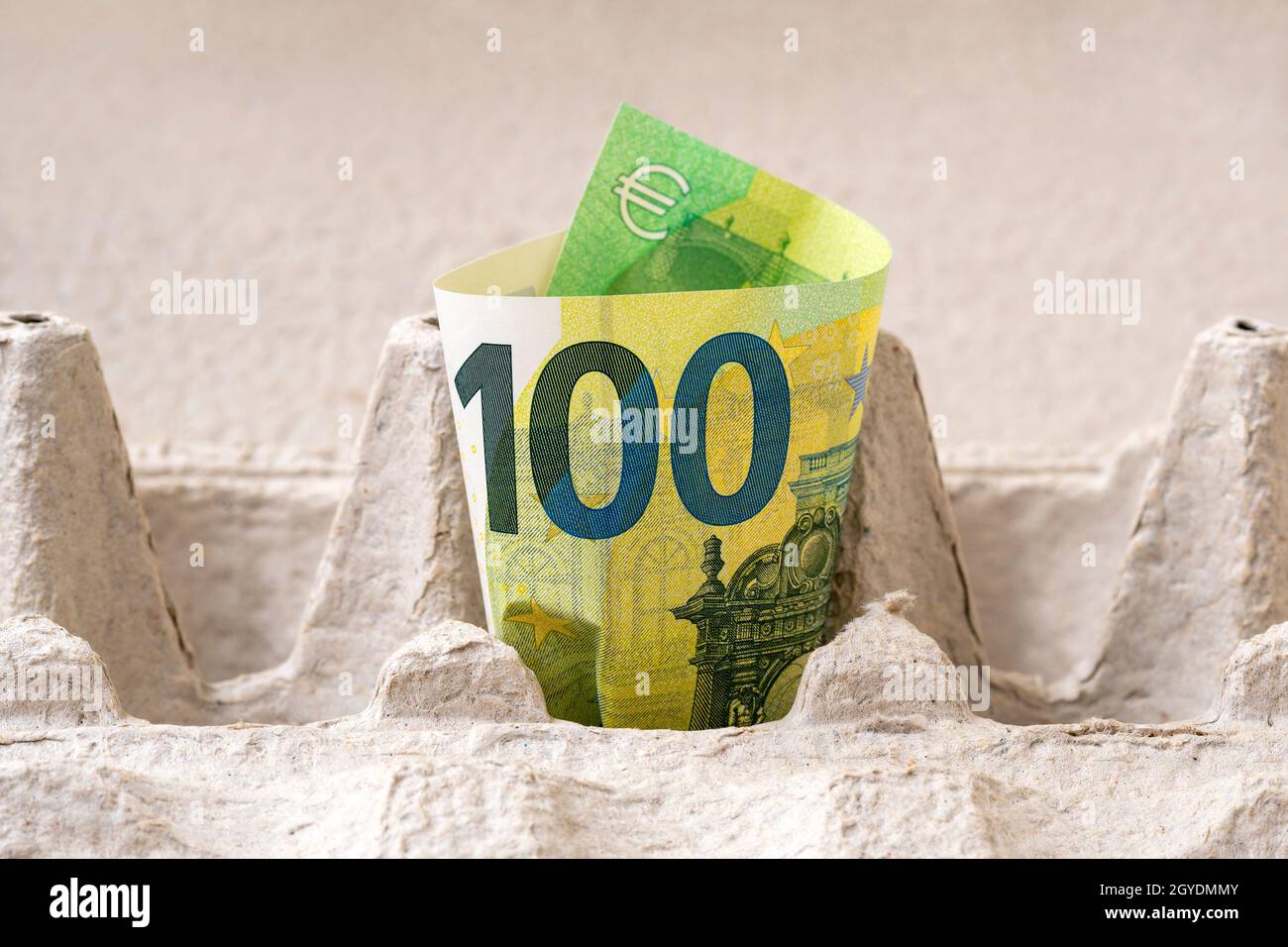 One hundred Euro bill in an egg cardboard box. Conceptual image. Stock Photo