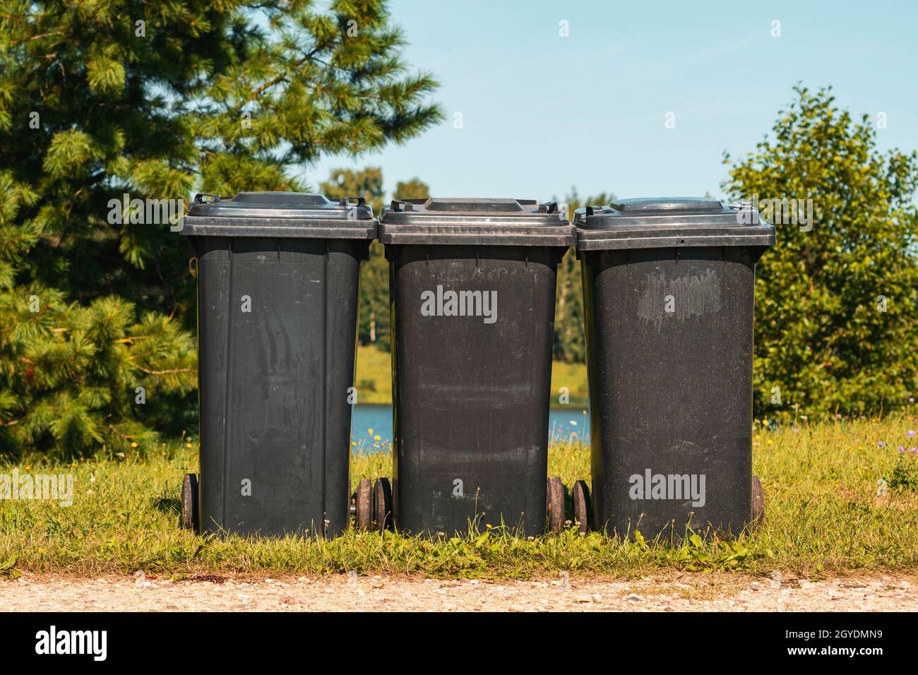 Three black plastic waste bins in the city park Stock Photo Alamy