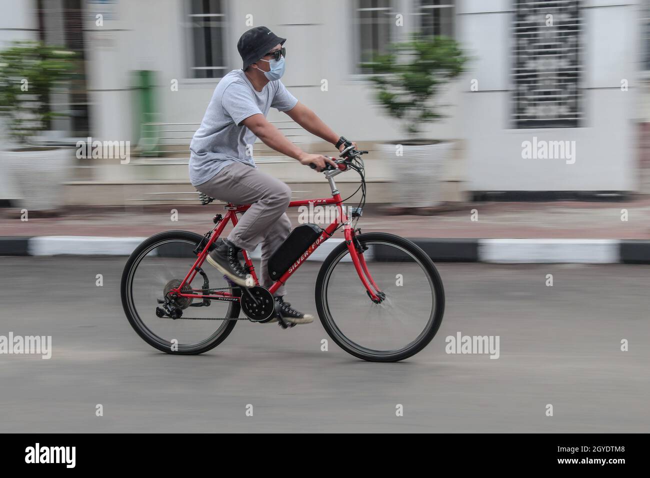 Bandung, Indonesia. 07th Oct, 2021. A mechanic rides a bicycle that has been modified into an electric bicycle at the Arusik Bikes workshop in Bandung. The standard bicycle innovation that is modified using electricity relies on an additional dynamo on the bicycle wheel using a 'pedal assist' and 'gas throttle' system that can last up to 70 kilometers. The custom bicycle battery power 'Arusik Bike' ranges from 250 to 300 watts with a battery charging time of 4 hours from zero to full. Credit: SOPA Images Limited/Alamy Live News Stock Photo