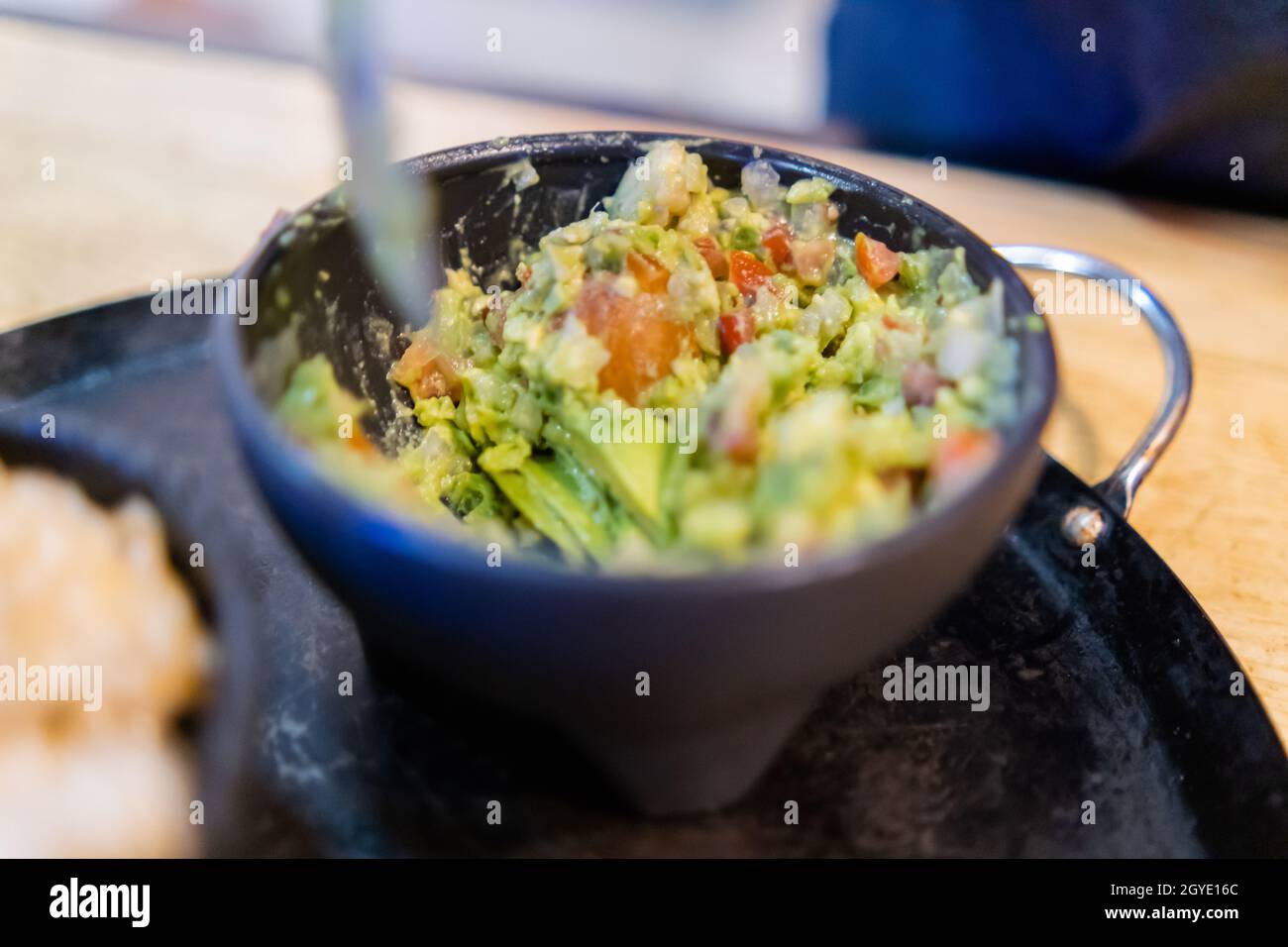 https://c8.alamy.com/comp/2GYE16C/black-bowl-of-delicious-guacamole-on-traditional-mexican-comal-2GYE16C.jpg
