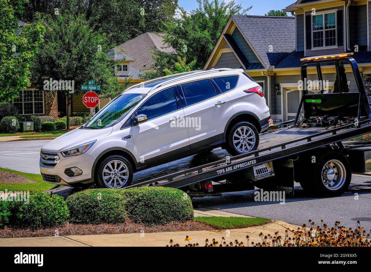SUV Being Loaded Onto Flatbed Tow Truck Stock Photo