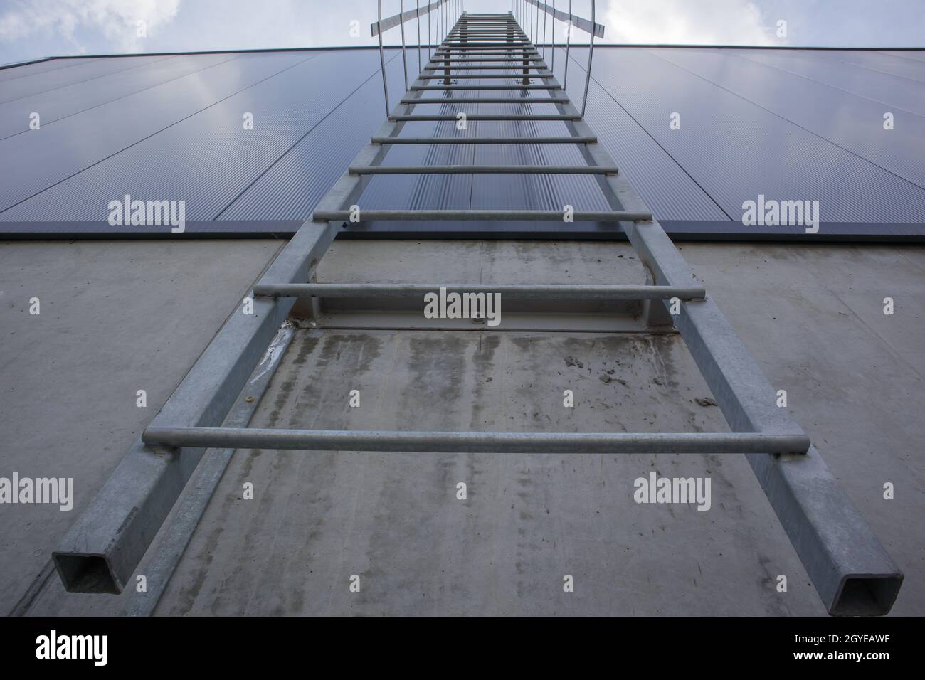 Fire escape on the industrial building above, bottom view. Stainless steel  handrails, roof ladder. Detail view of stairs with safety cage. Building co  Stock Photo - Alamy