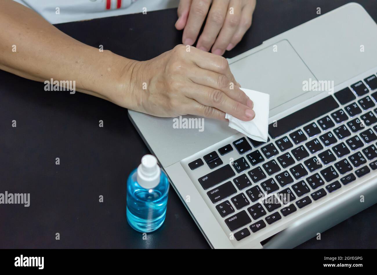 Spraying alcohol to clean the computer and wipe the germs. Health care