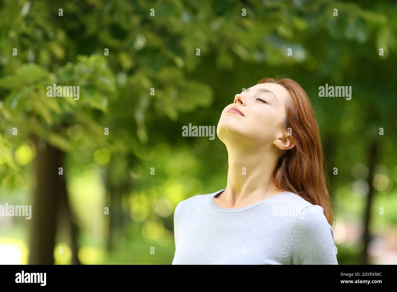 Beautiful woman relaxing breathing fresh air standing in a park Stock ...