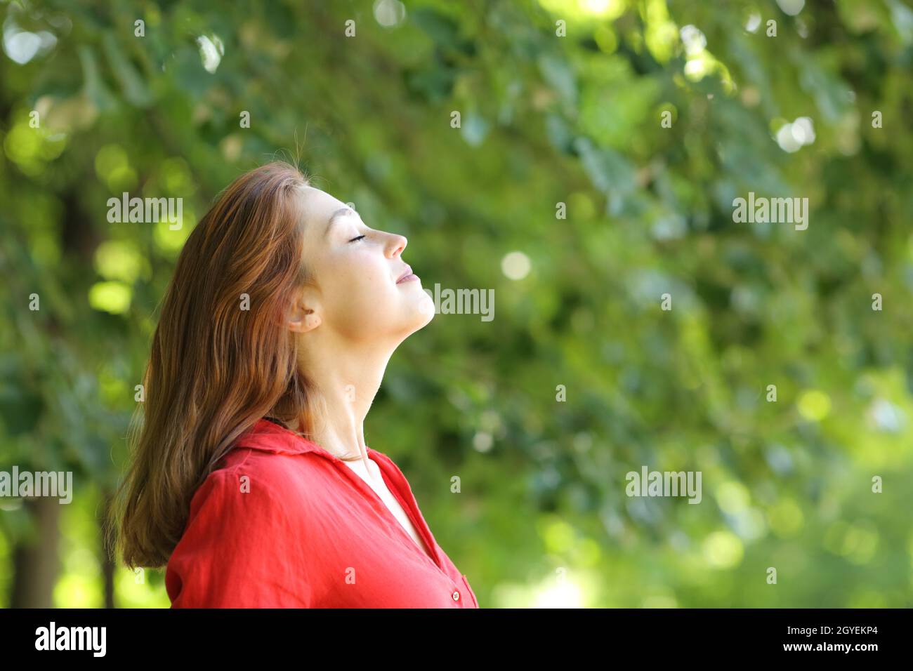 Profile of a woman in red breathing fresh air in a green park Stock ...