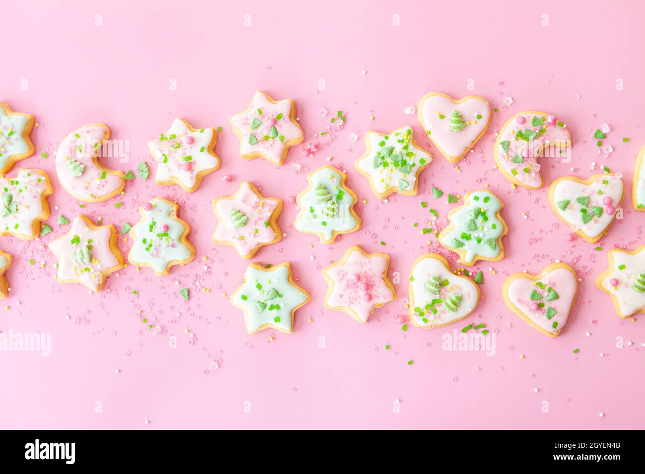 Colorful Christmas cookies with sugar sprinkles on a pink background Stock Photo