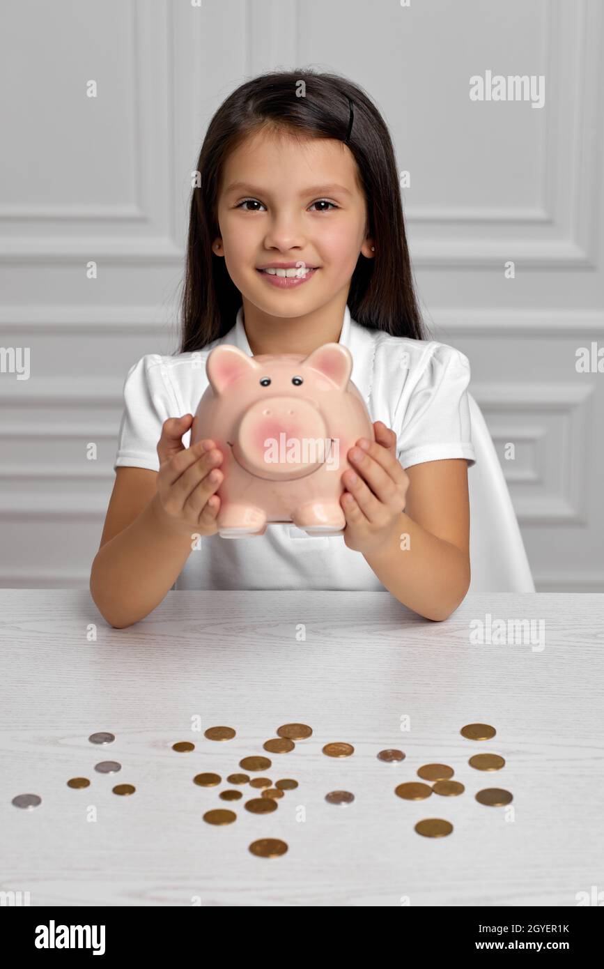 happy child girl holding pink piggy bank at home Stock Photo - Alamy