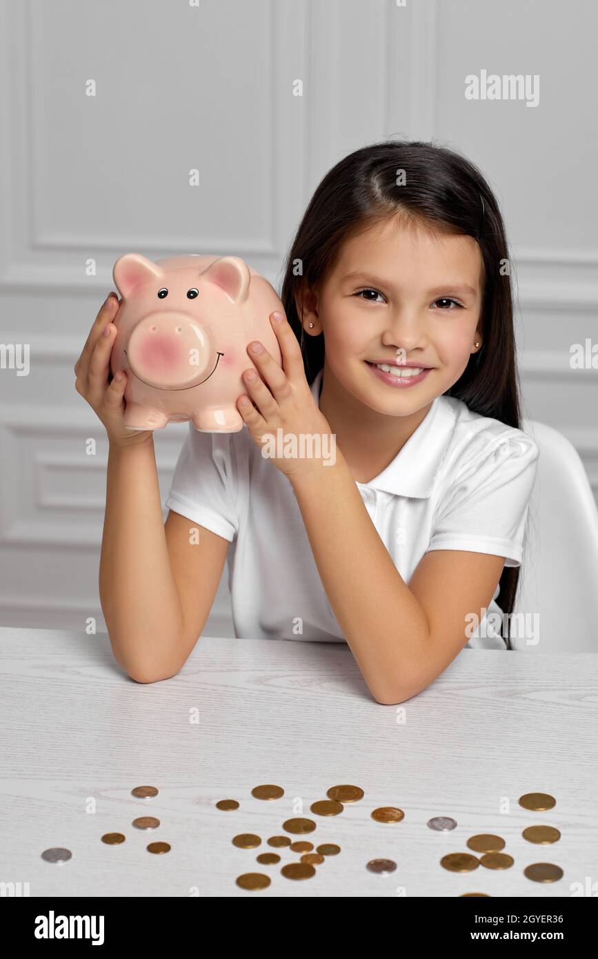 happy child girl holding pink piggy bank at home Stock Photo - Alamy