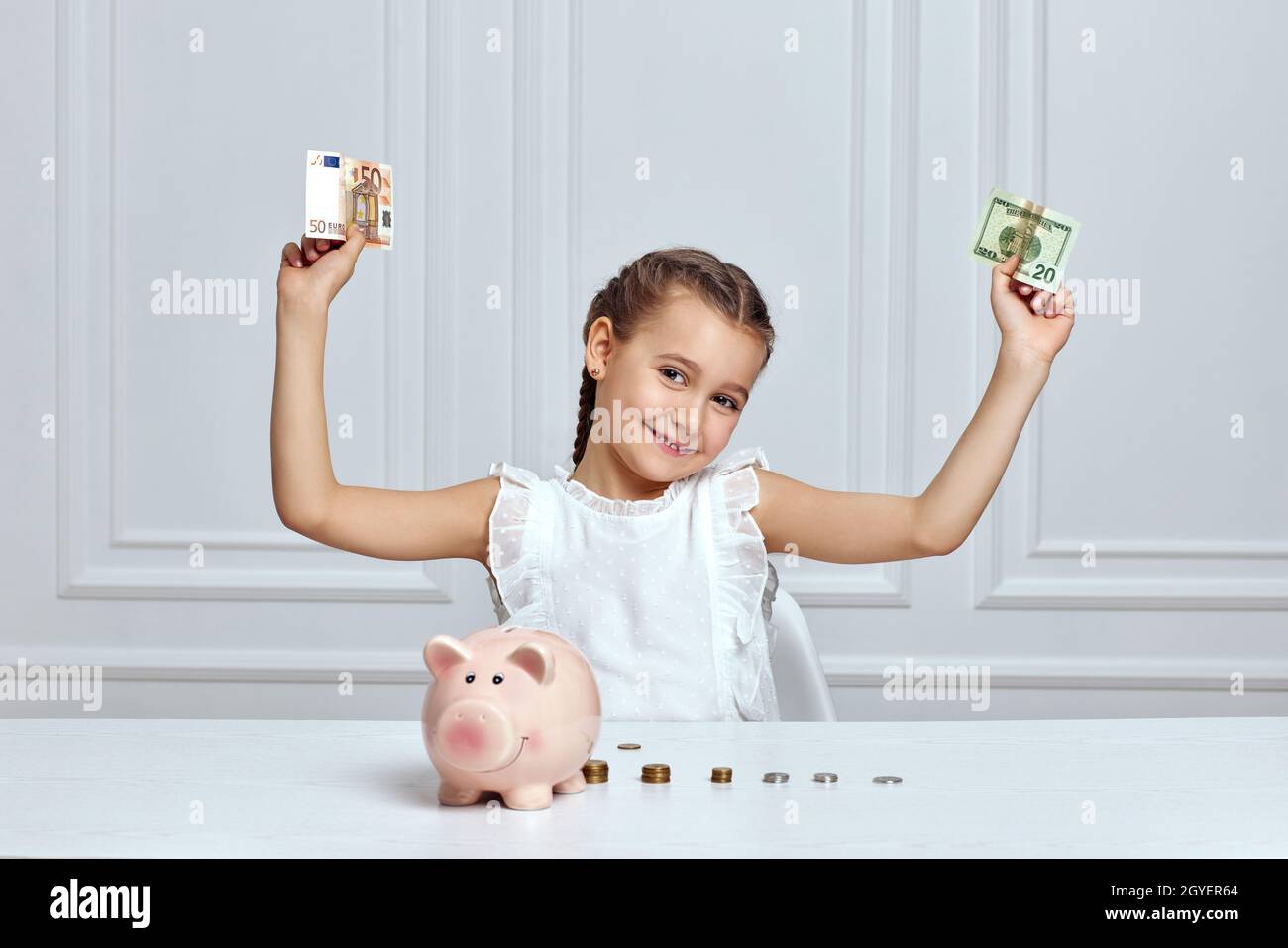 happy cute little girl saving money in pink piggy bank Stock Photo - Alamy
