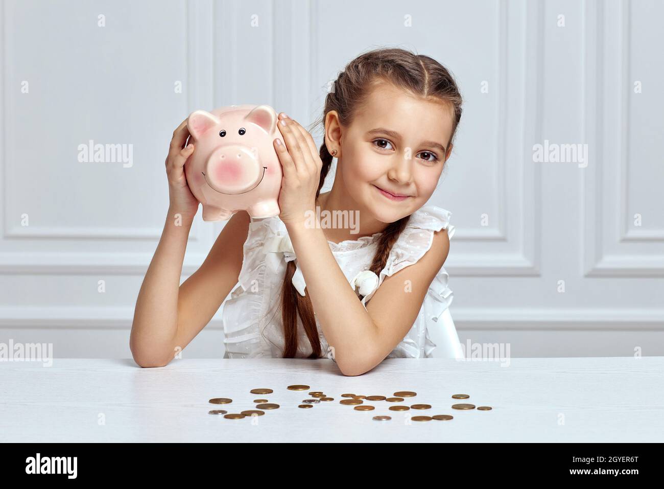 happy little child girl saving money for future in pink piggy bank ...