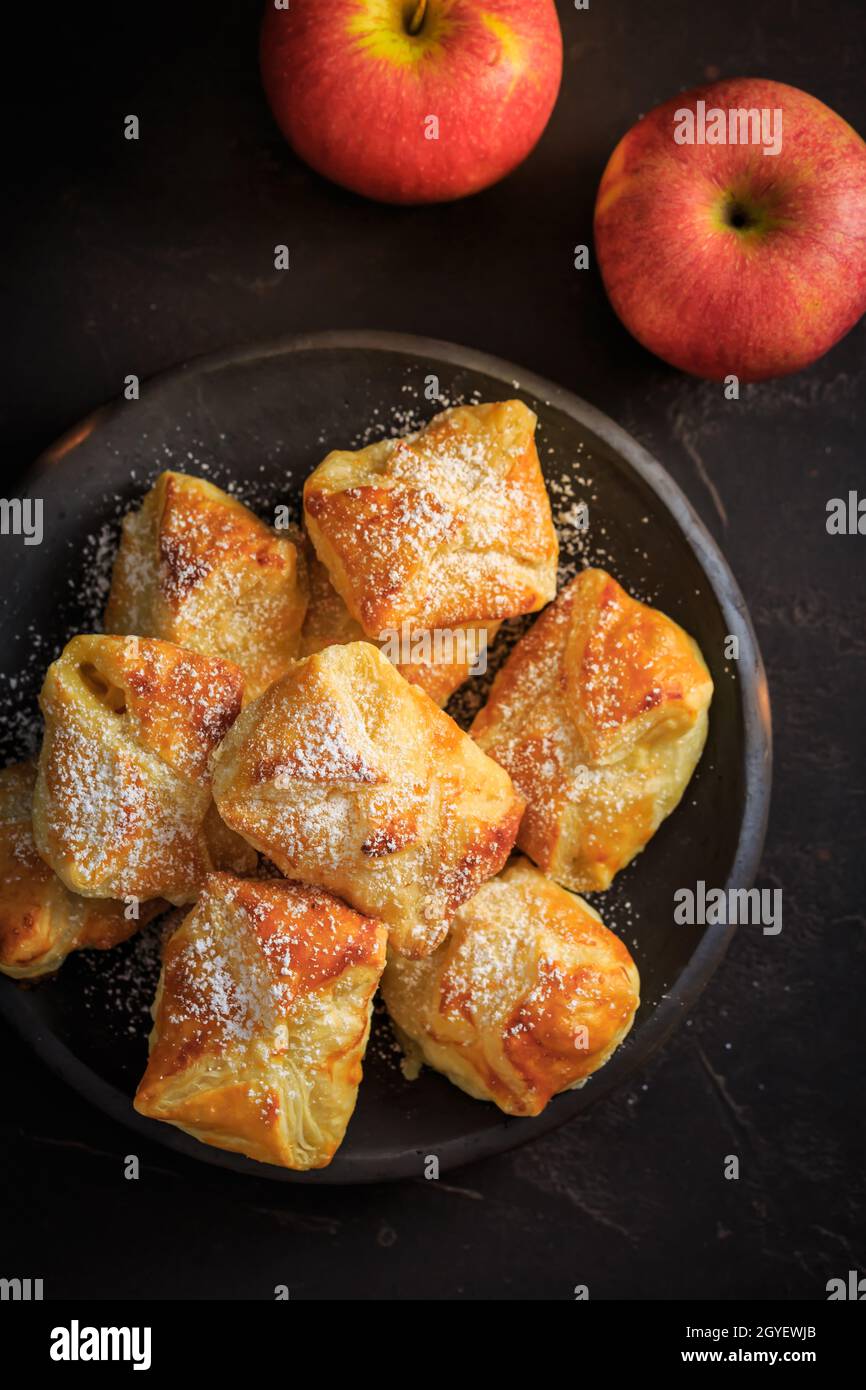 Homemade small apple turnovers in bowl on black background Stock Photo